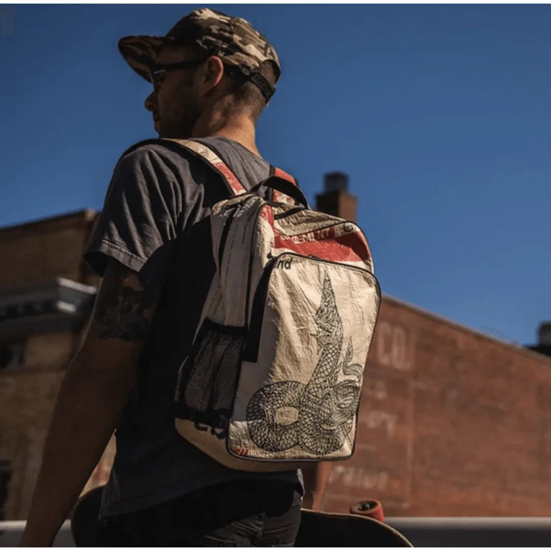 Man outside wearing a white and red backpack with naga on it.