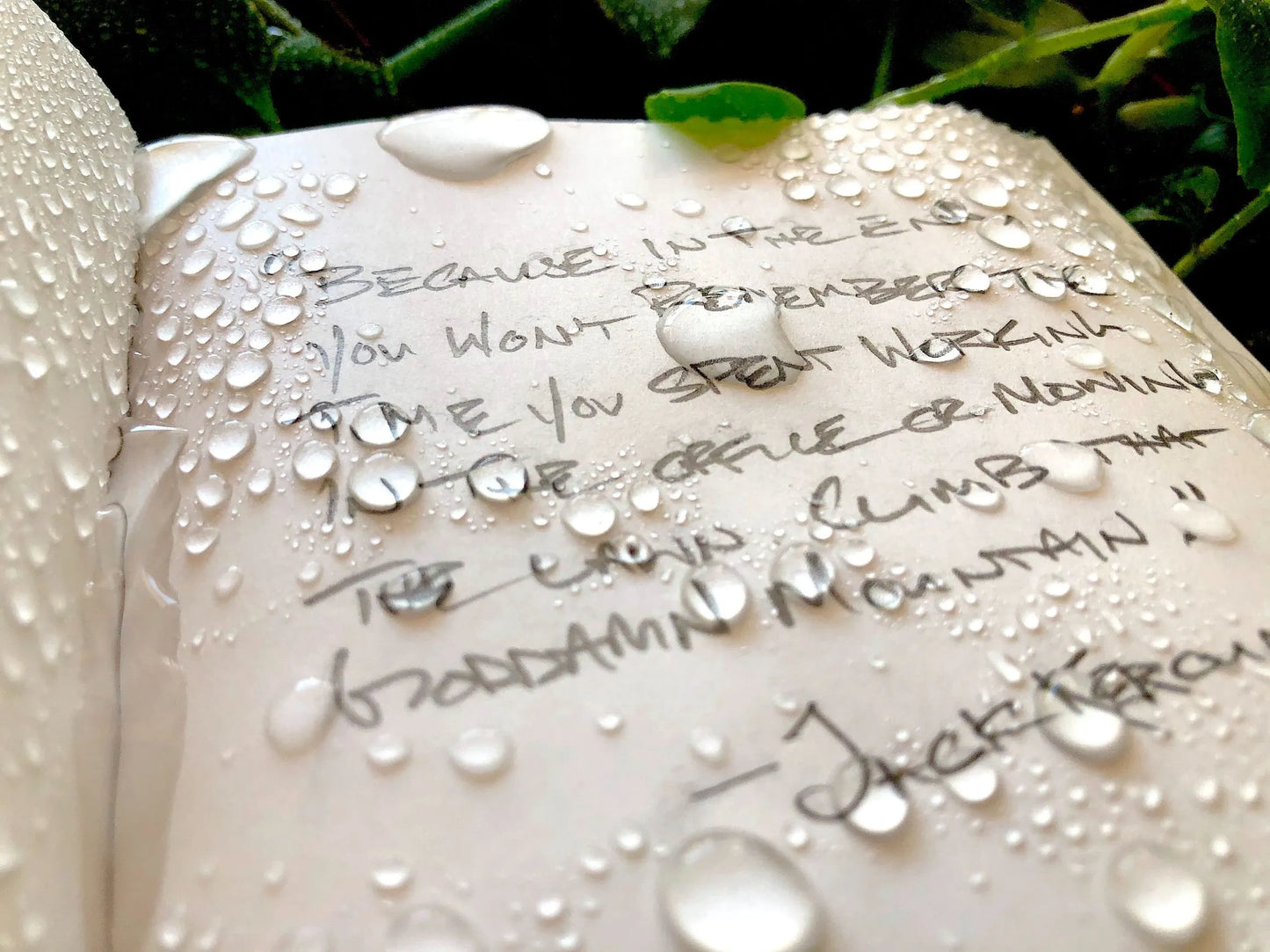 Notepad paper with writing and water on it.