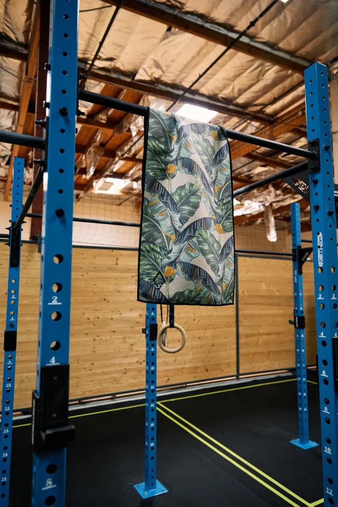 Mini towel with green and black leaves hanging in a gym.