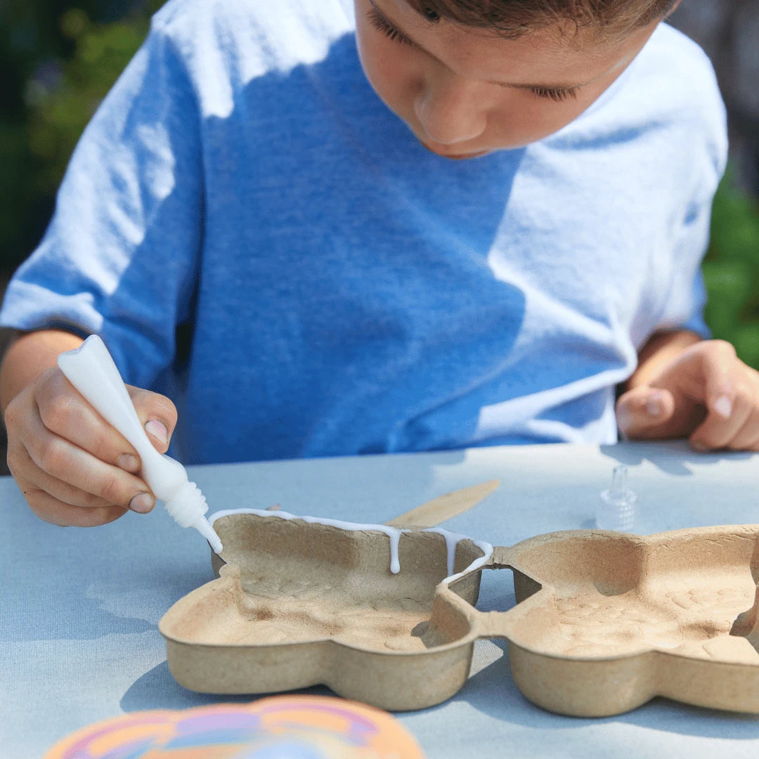 Kid glueing a butterfly activity kit.