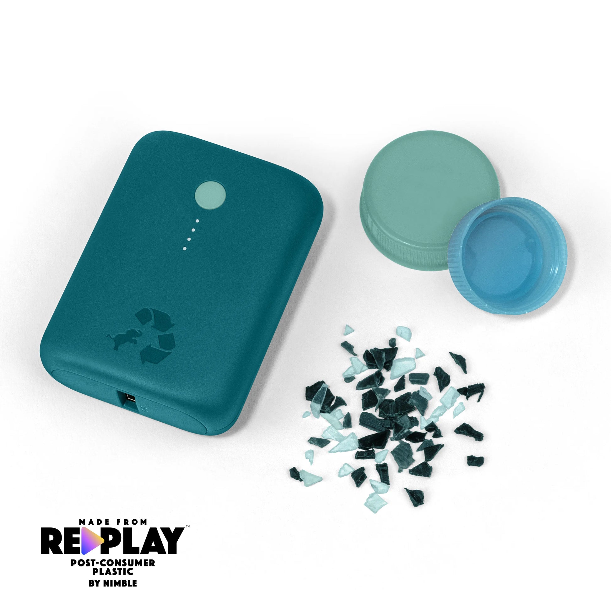 Turquoise portable charger with green button next to bottle caps and shredded plastic.