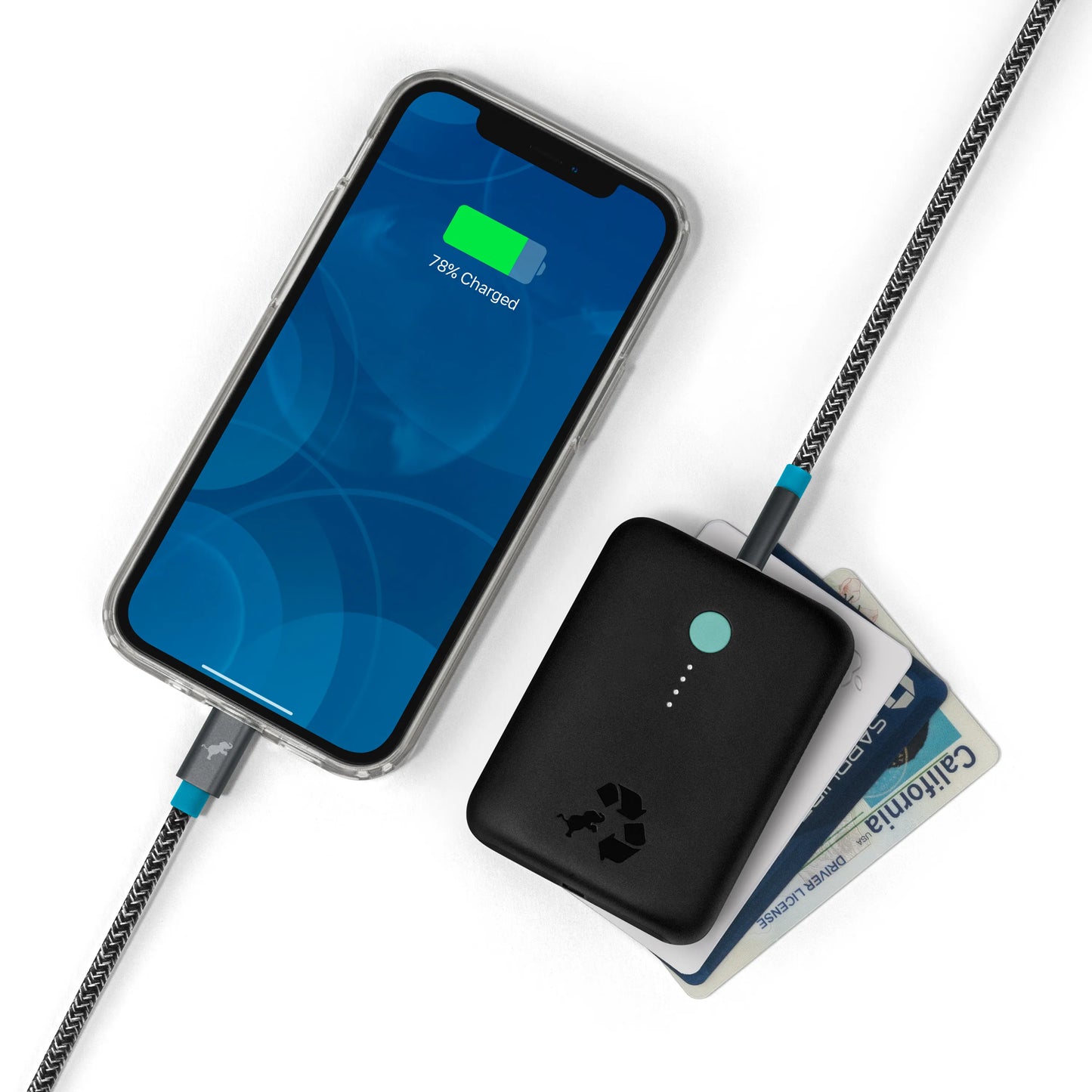 Black portable charger with green button connected to cell phone.
