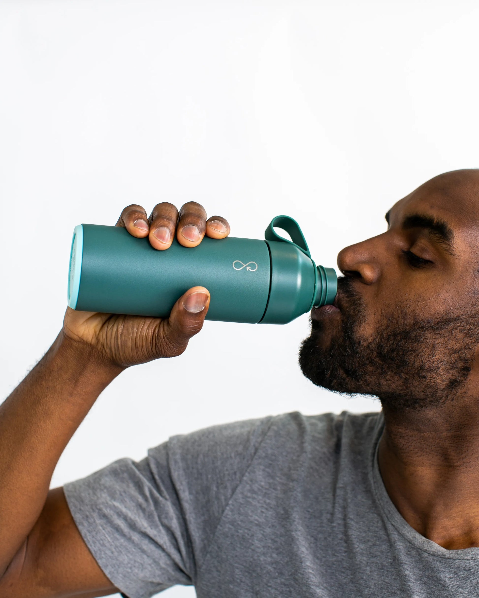 Man drinking out of a green water bottle.
