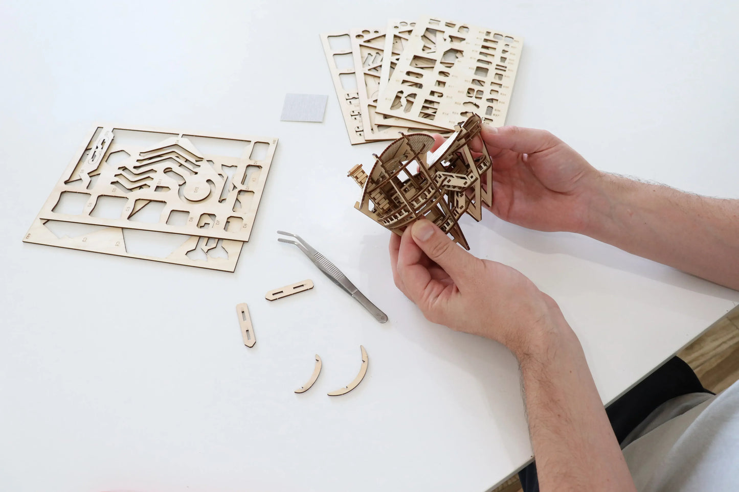 Person building a tiny treehouse kit.