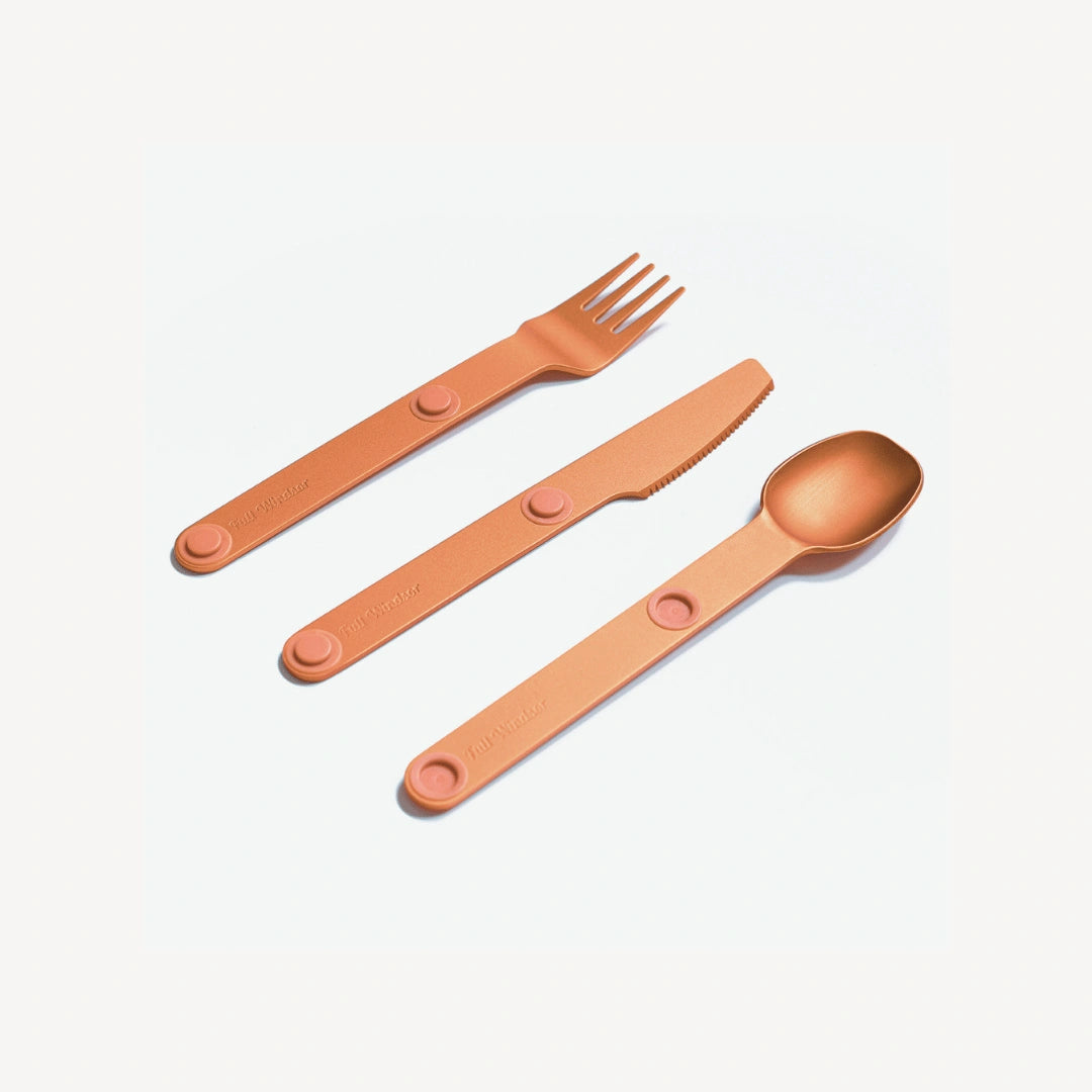 Orange fork, spoon and knife angled.