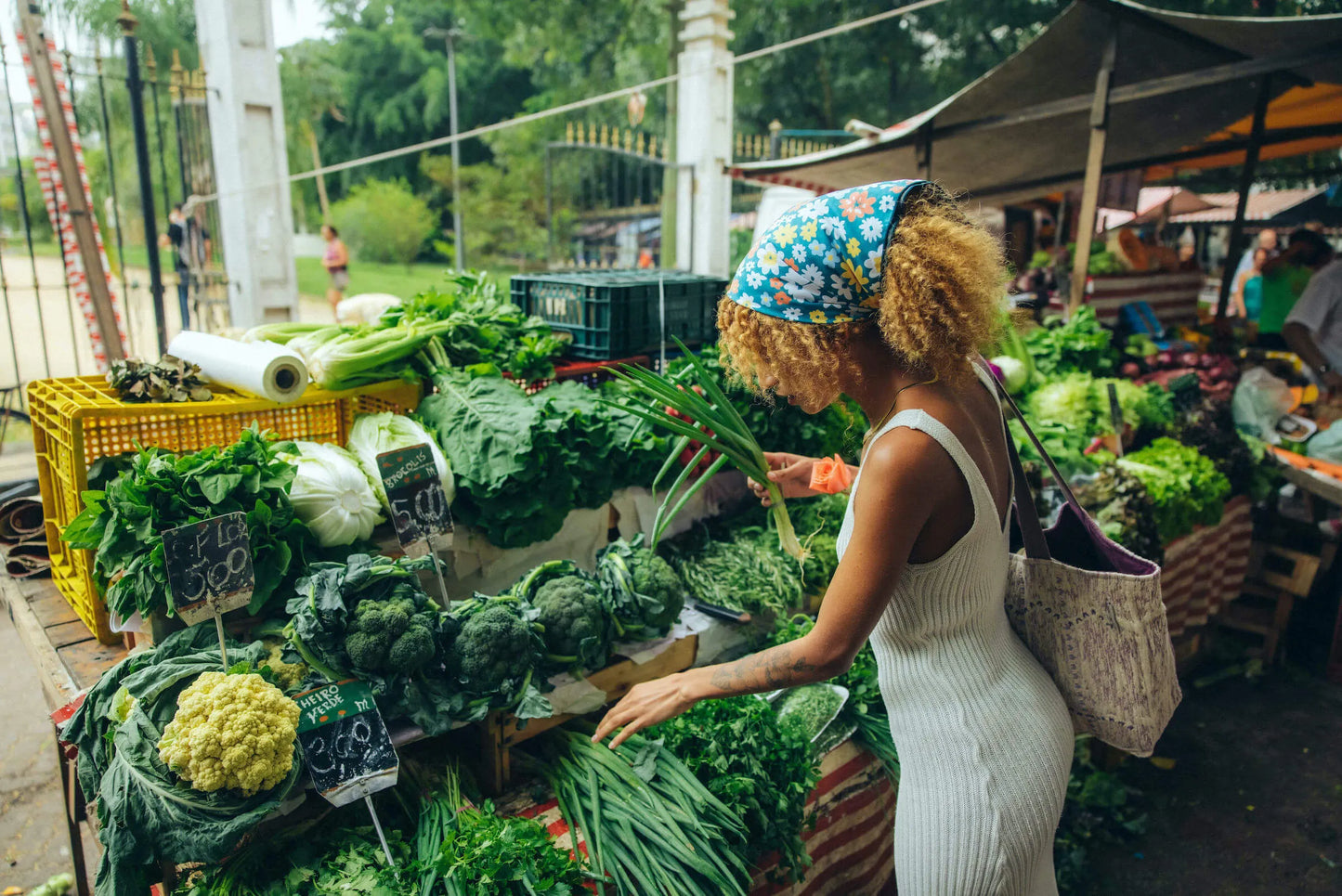 Woman shopping for vegetables with a bandana in her hair.