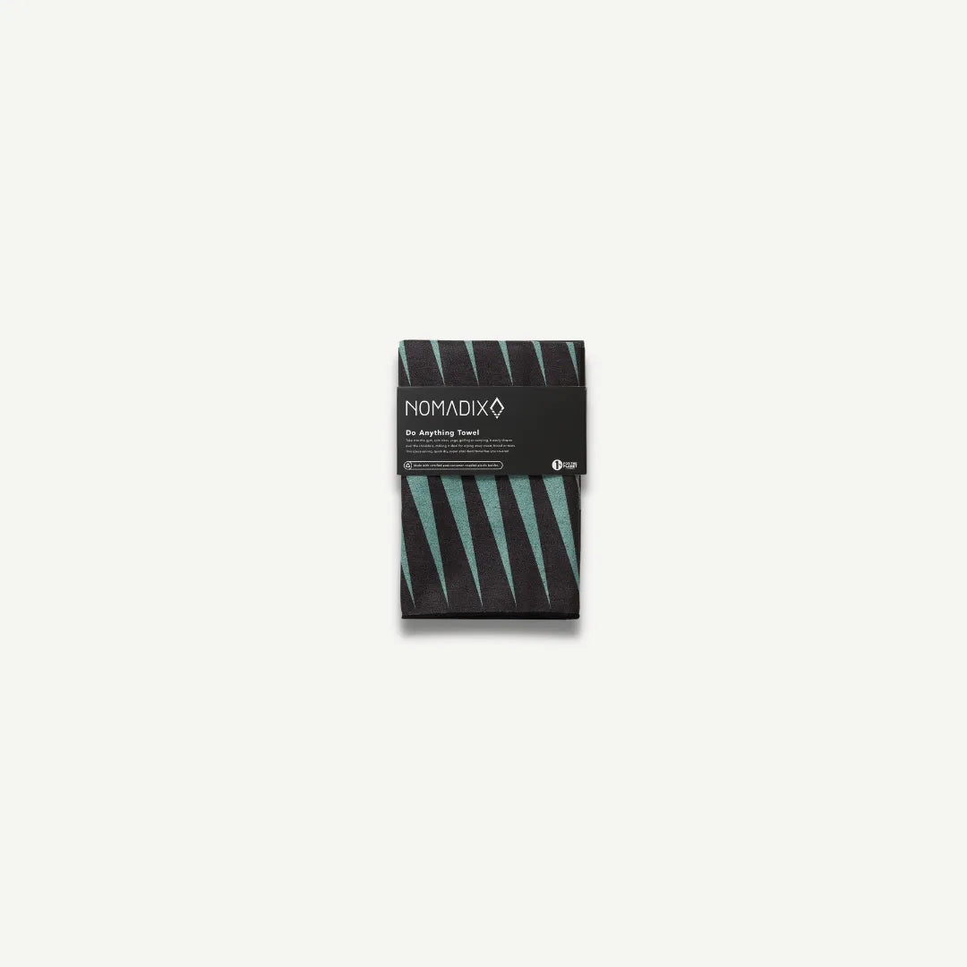 Mini towel with teal and black lines in packaging.