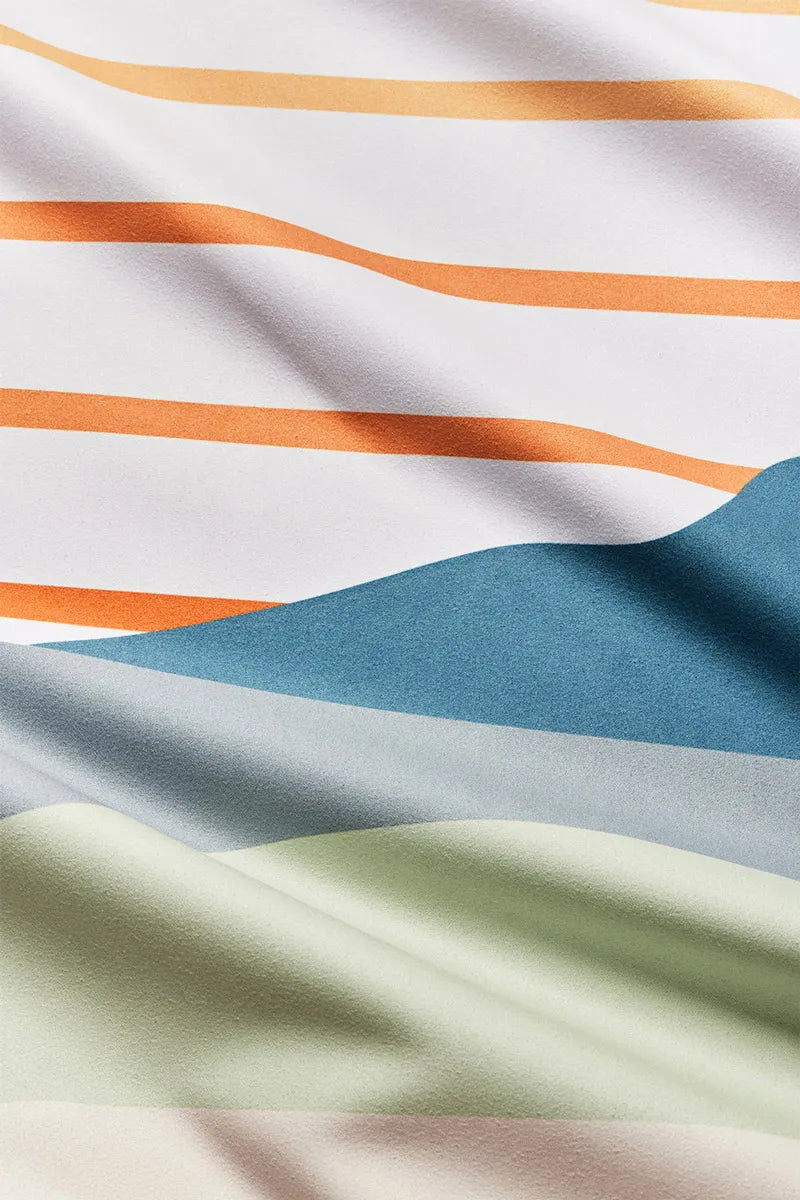Close up of white towel with multi-colored lines and hills.