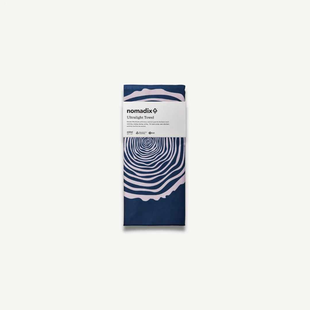 Navy blue towel with white tree ring circles in packaging.