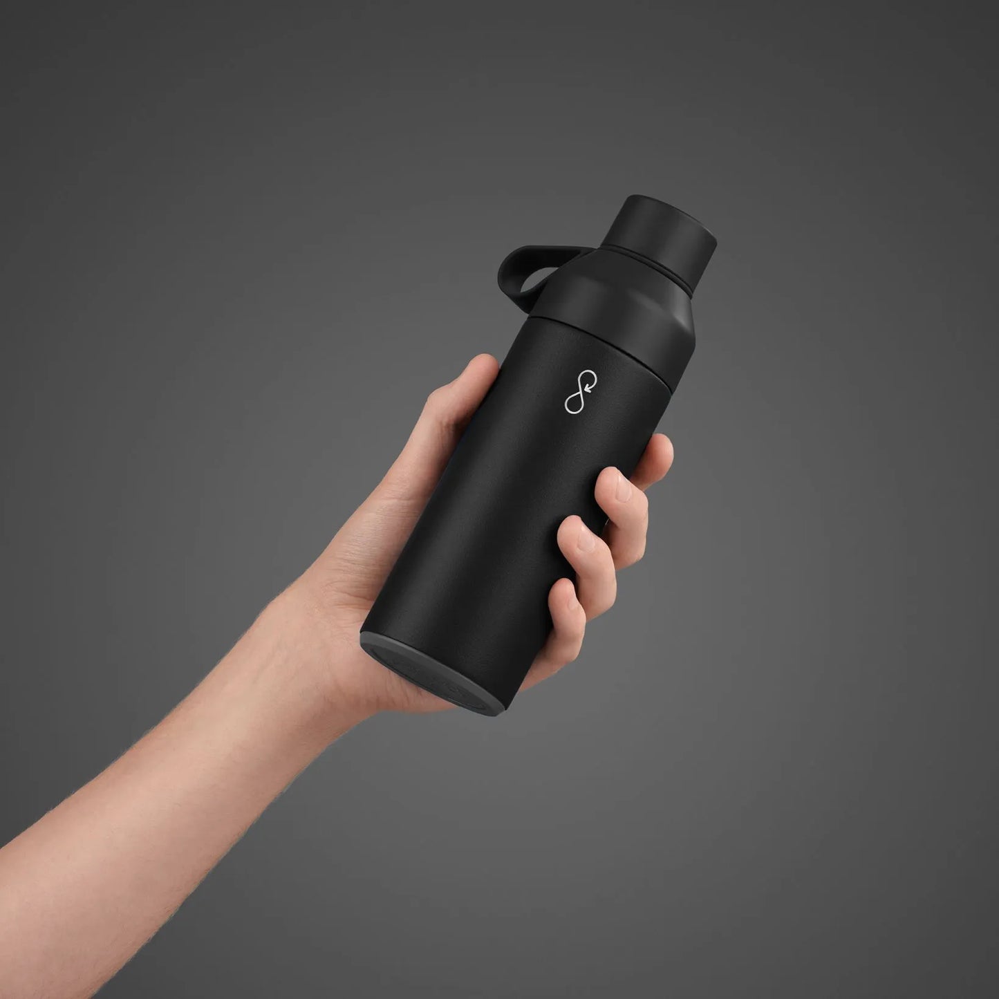 Hand holding a black water bottle.