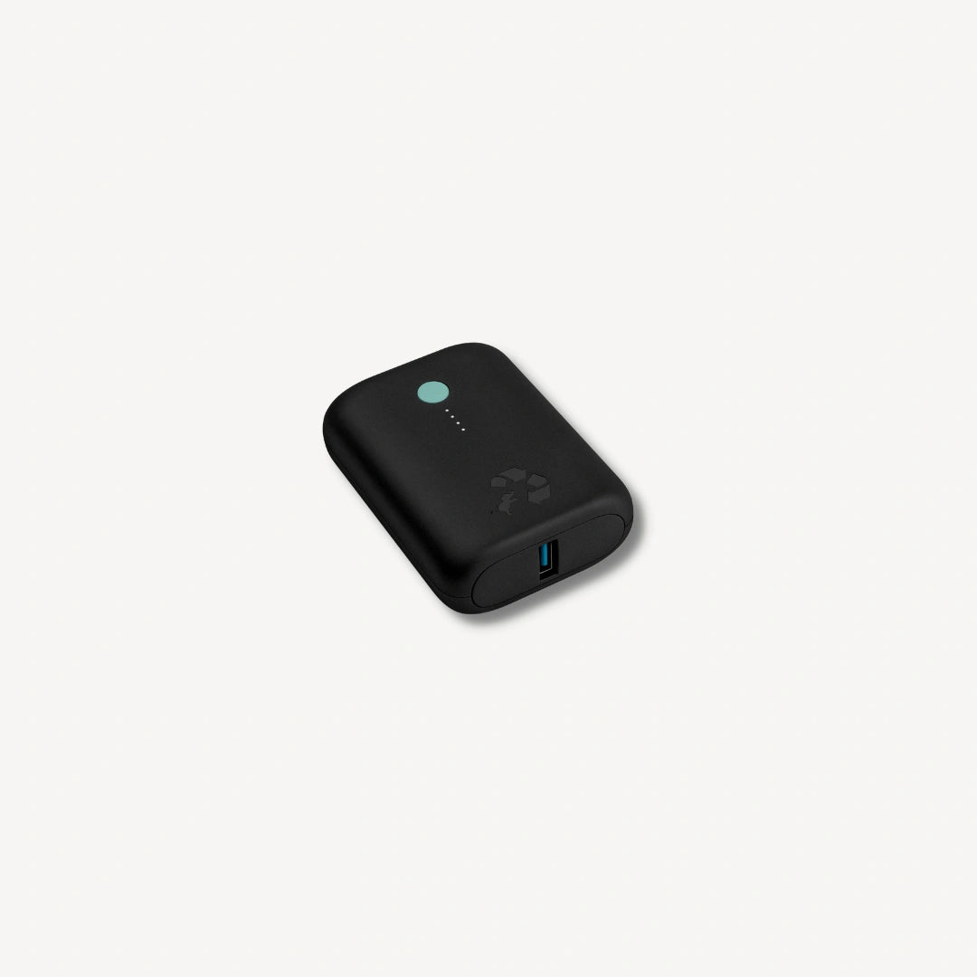 Black portable charger with green button angled.