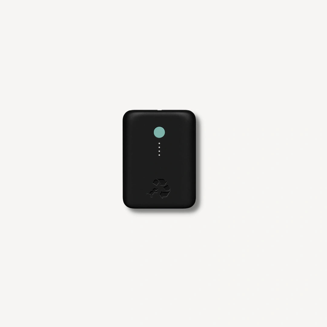 Black portable charger with green button.