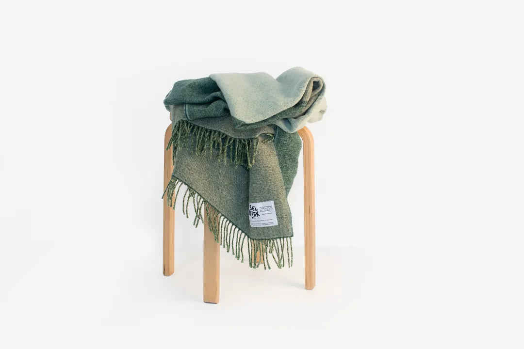 Green wool blanket draped over a stool.