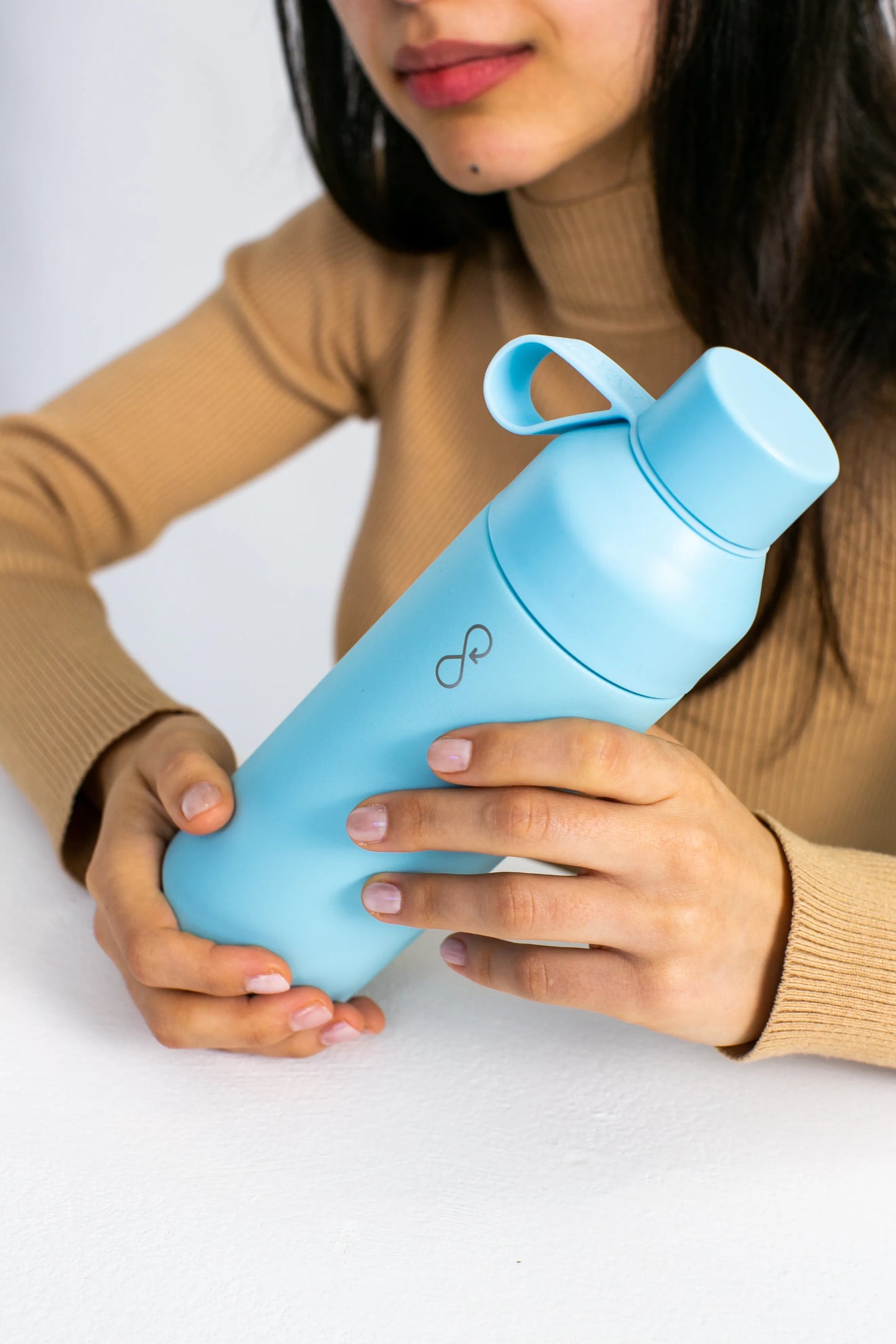 Woman with a blue water bottle in both hands.