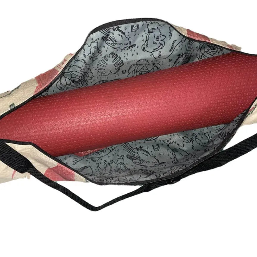 A red yoga mat on the inside of a yoga mat bag.