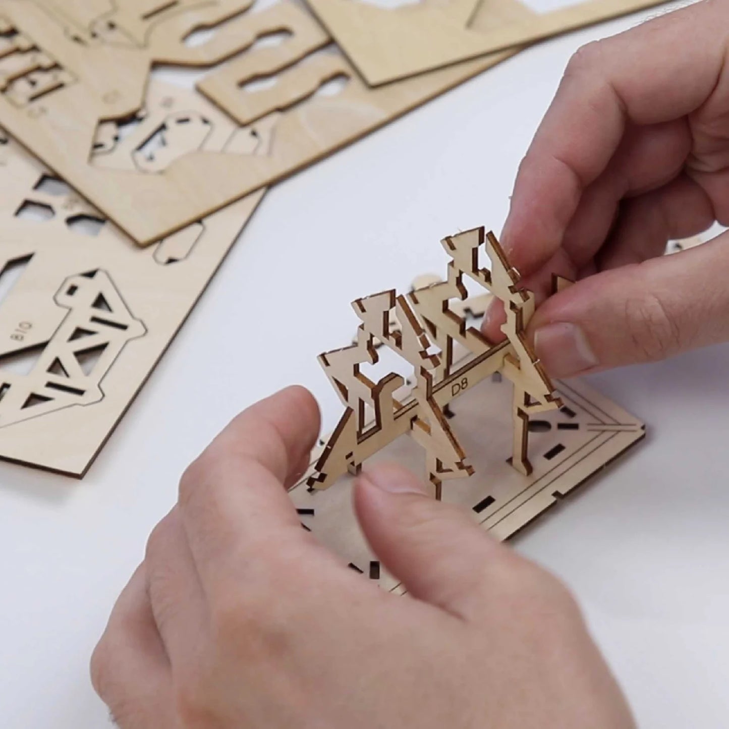 Hands building a tiny treehouse model kit