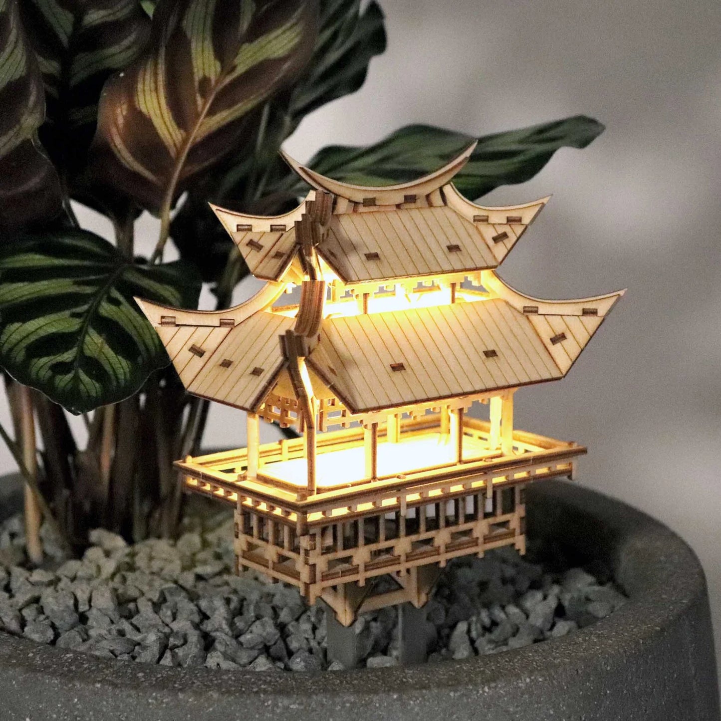 Wooden tiny treehouse with lights in potted plant