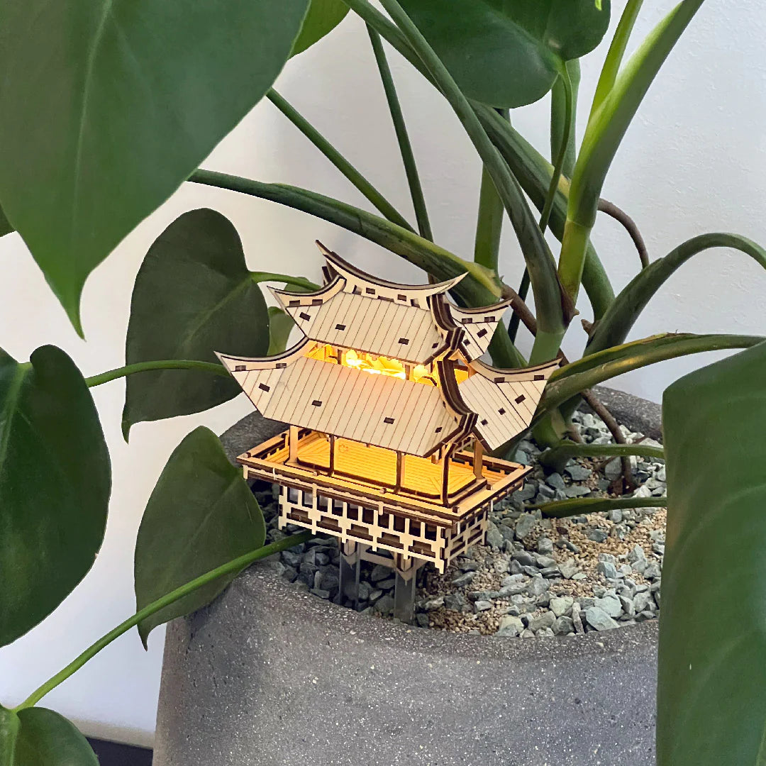 Wooden tiny treehouse with lights in potted plant