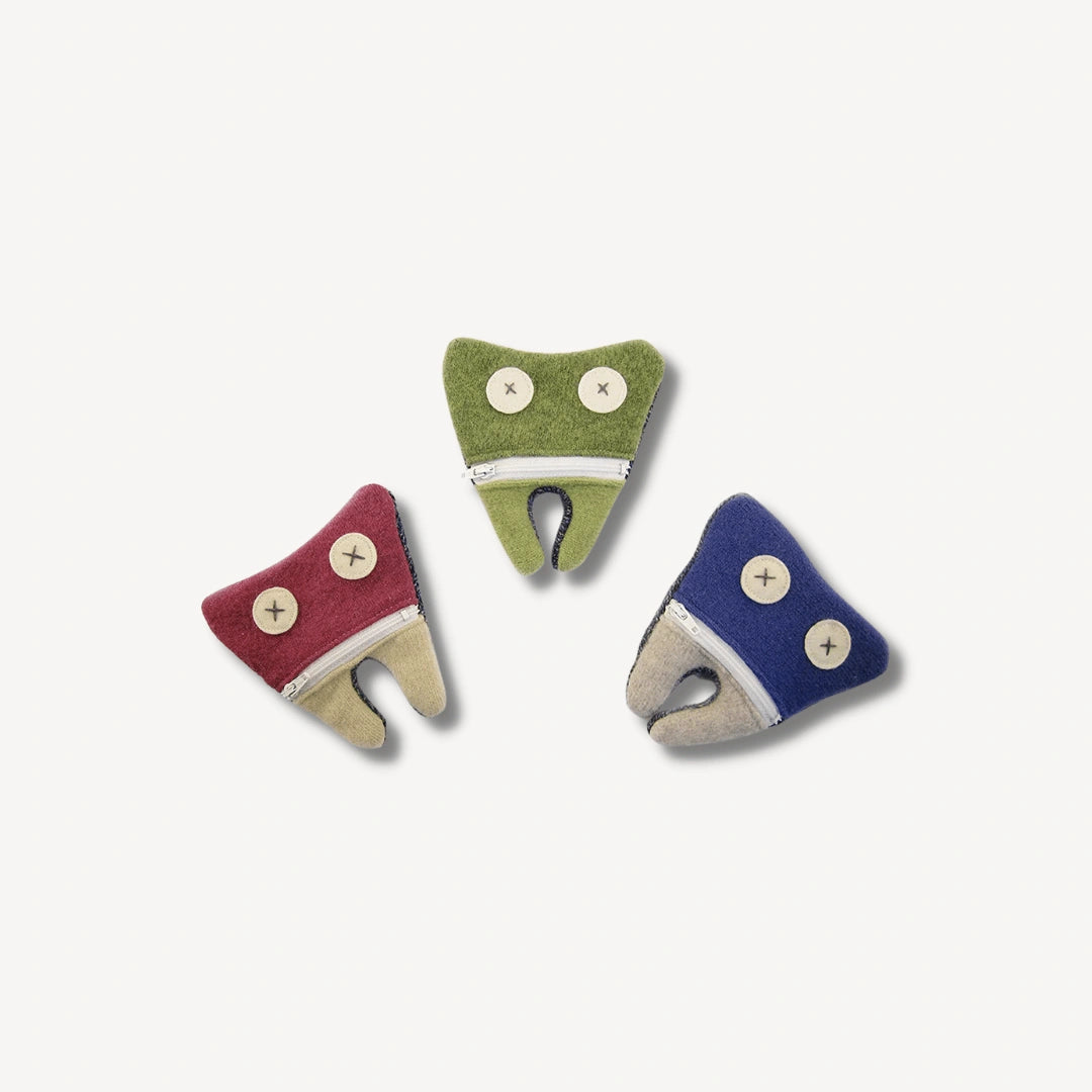 Three different colored tooth fairy pouches in the shape of a tooth.
