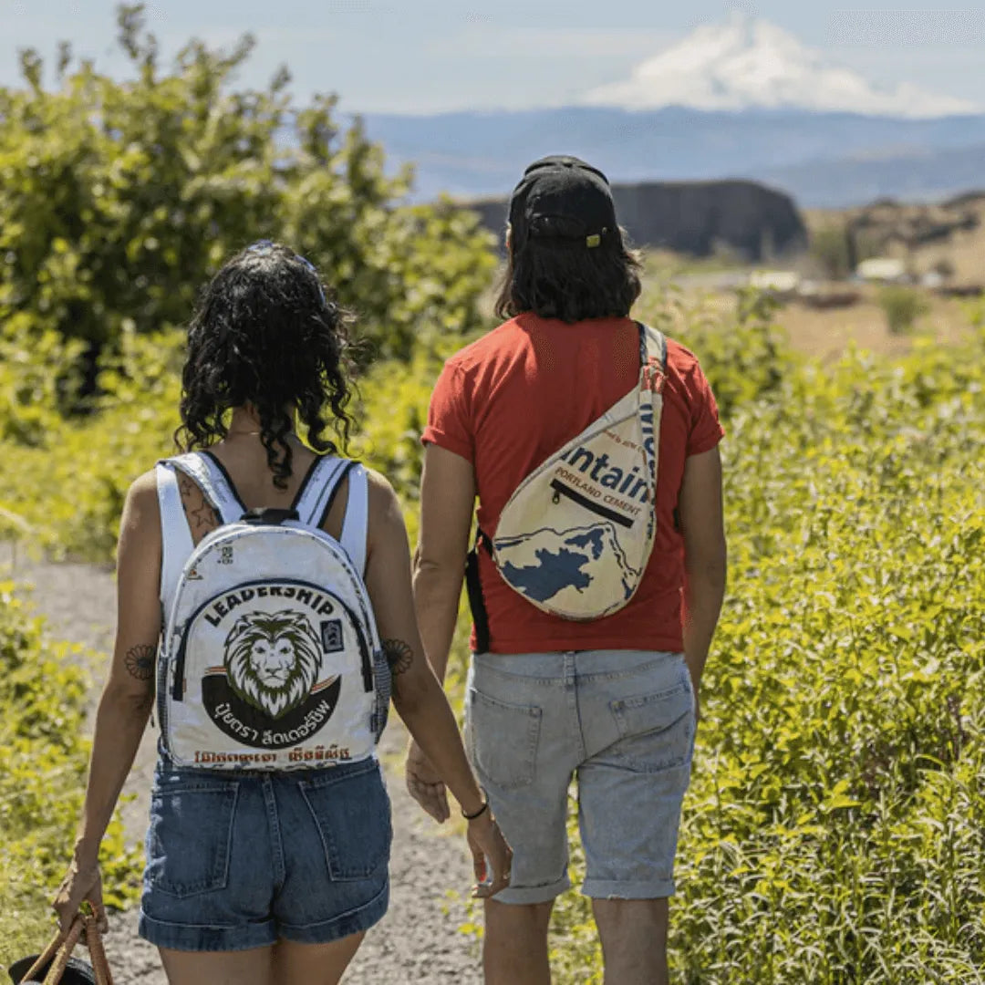 Man and woman hiking outside wearing backpacks.