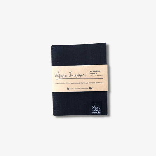 Black waxed journal notebook in packaging.