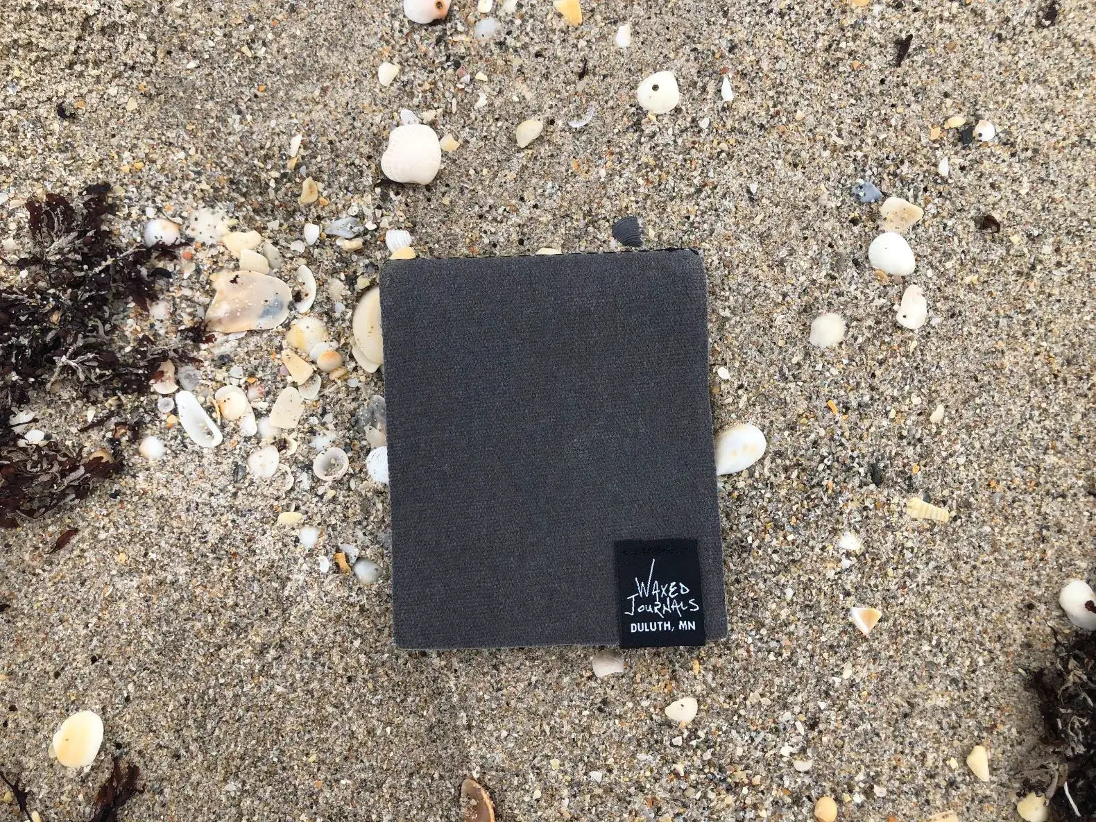 Gray notepad on a sandy beach.