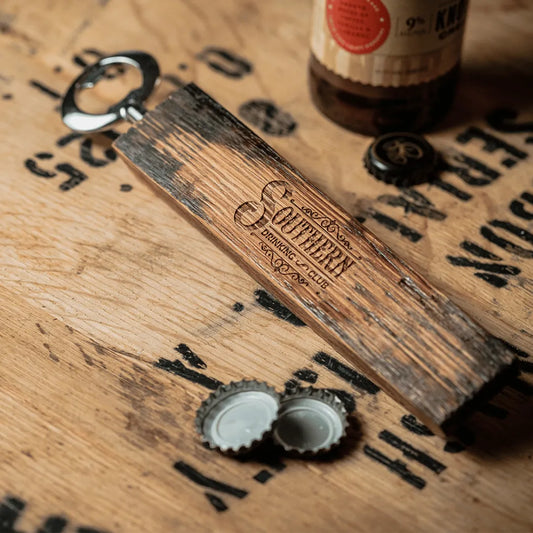 Wood bottle opener next to bottle and caps.