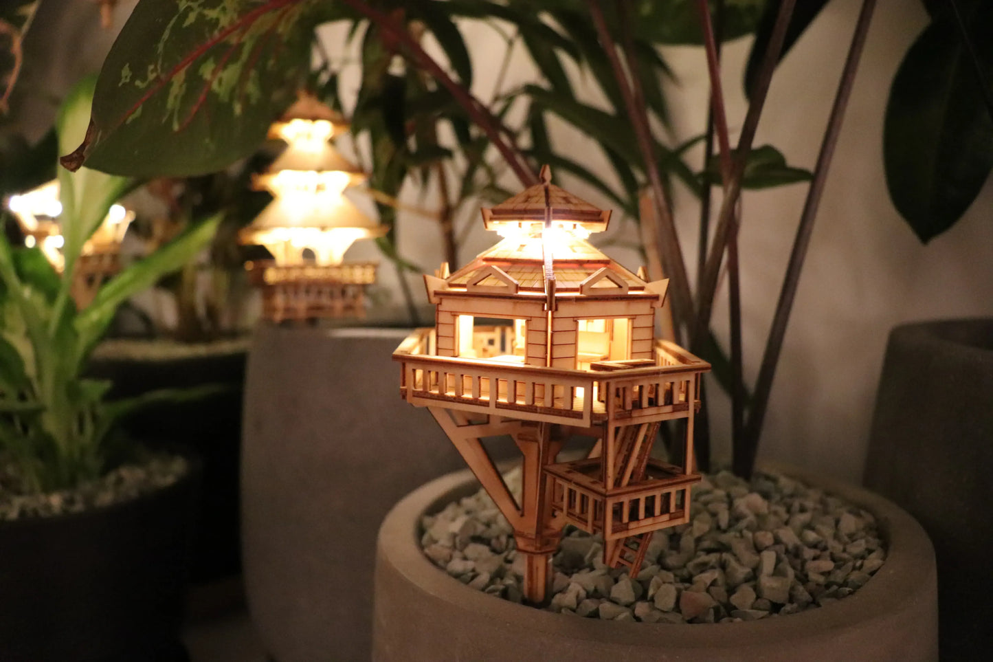 Multiple small wooden treehouses with lights on.