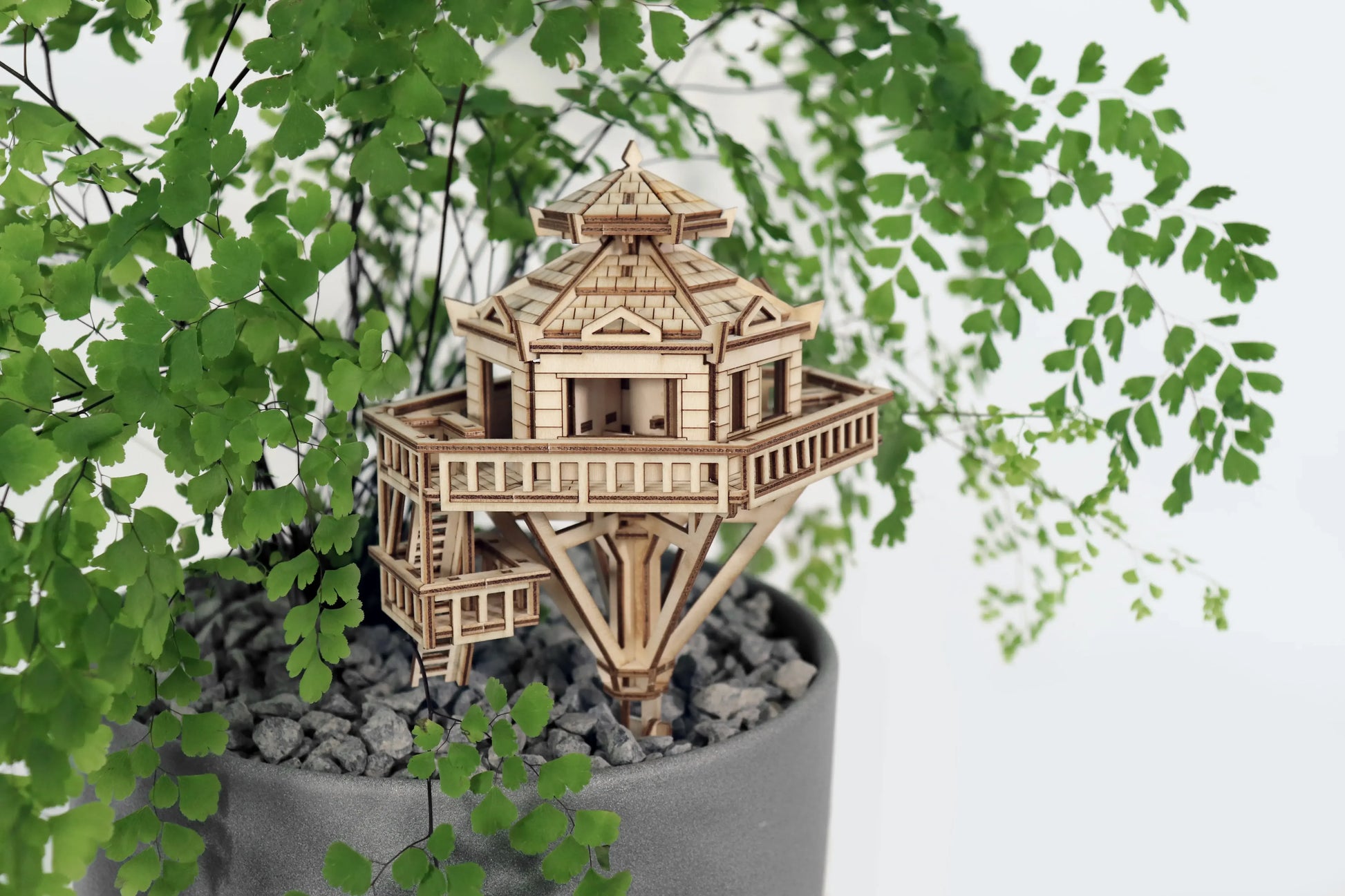 Small wooden treehouse in a potted plant.