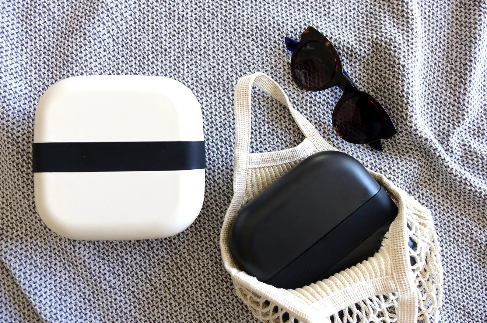 White and black bento boxes next to sunglasses.