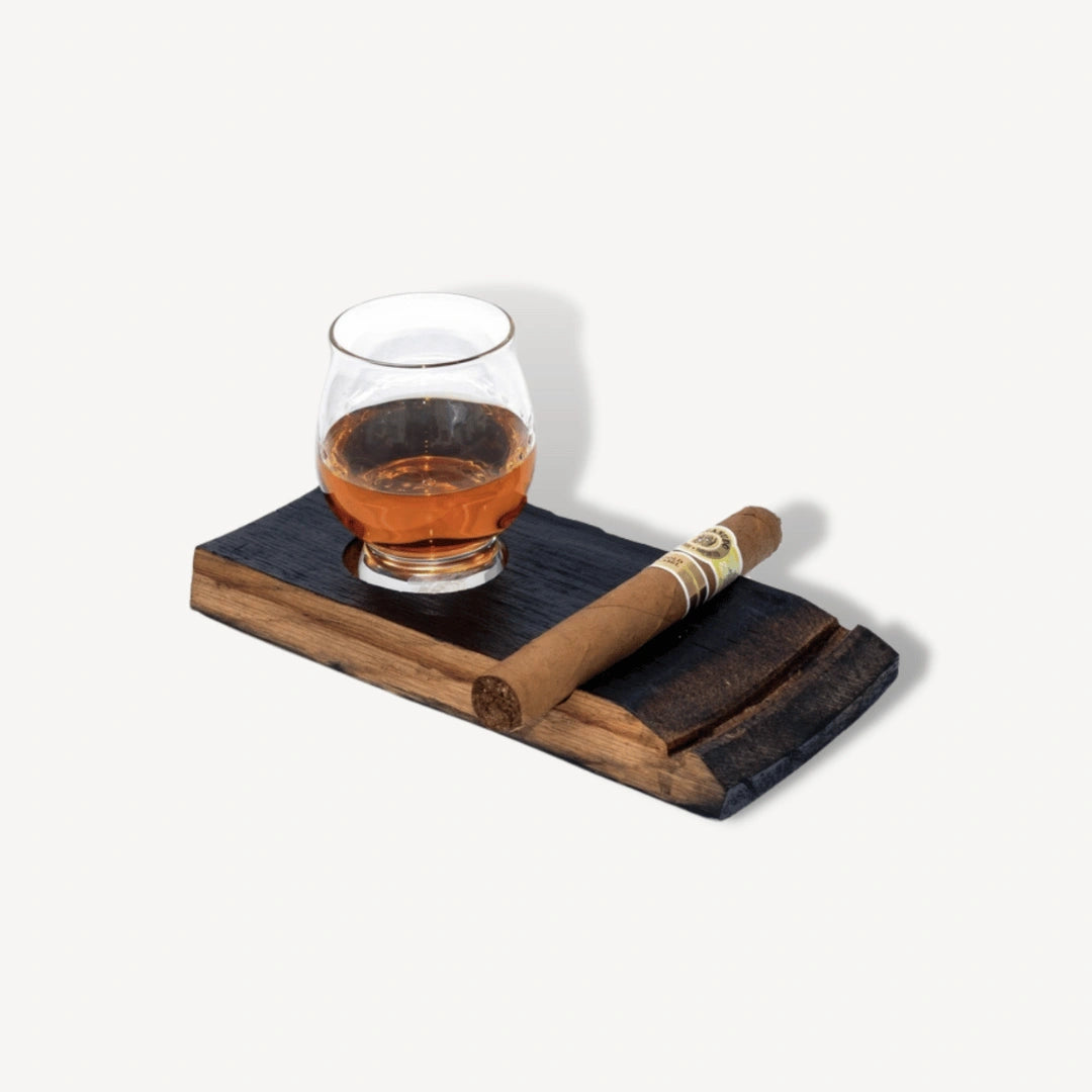 Whiskey in a glass and a cigar on a coaster.