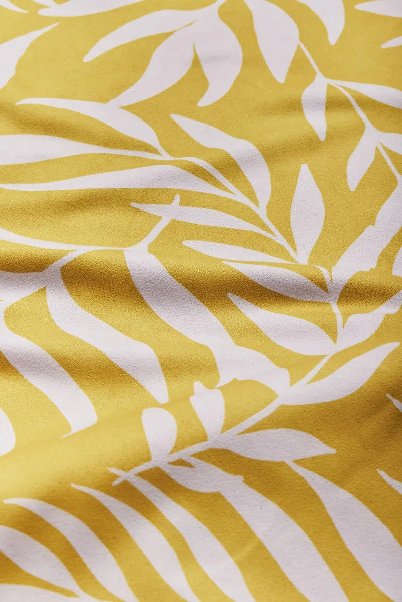 Close up of yellow bandana with white leaves.