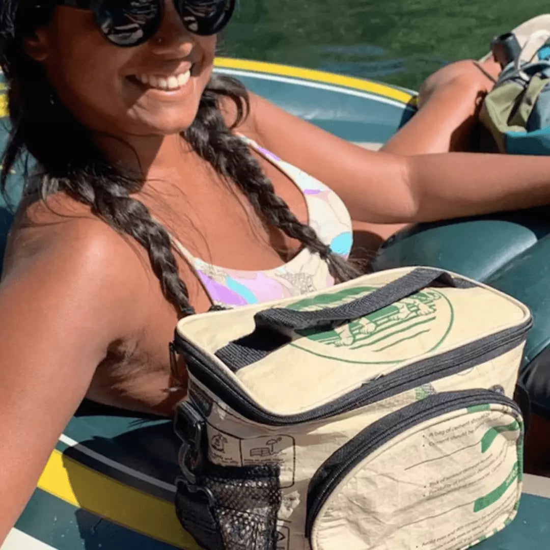 Woman in a tube on the water with a green and white cooler bag.
