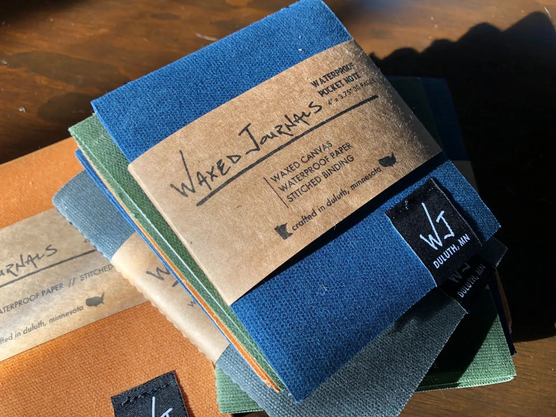 Multiple colors of waxed journal notepads.