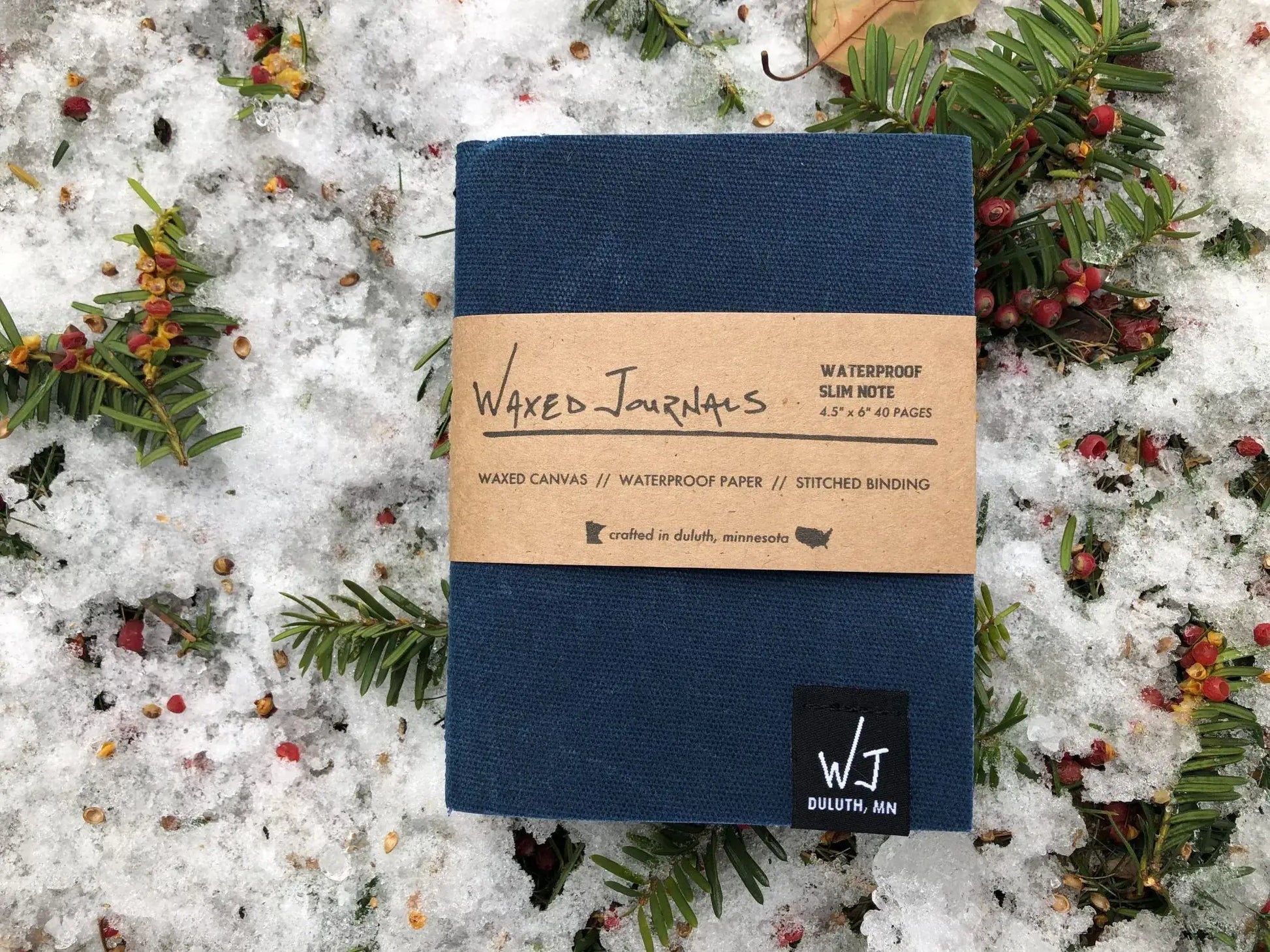 Blue waxed journal notebook in packaging outside on snow.