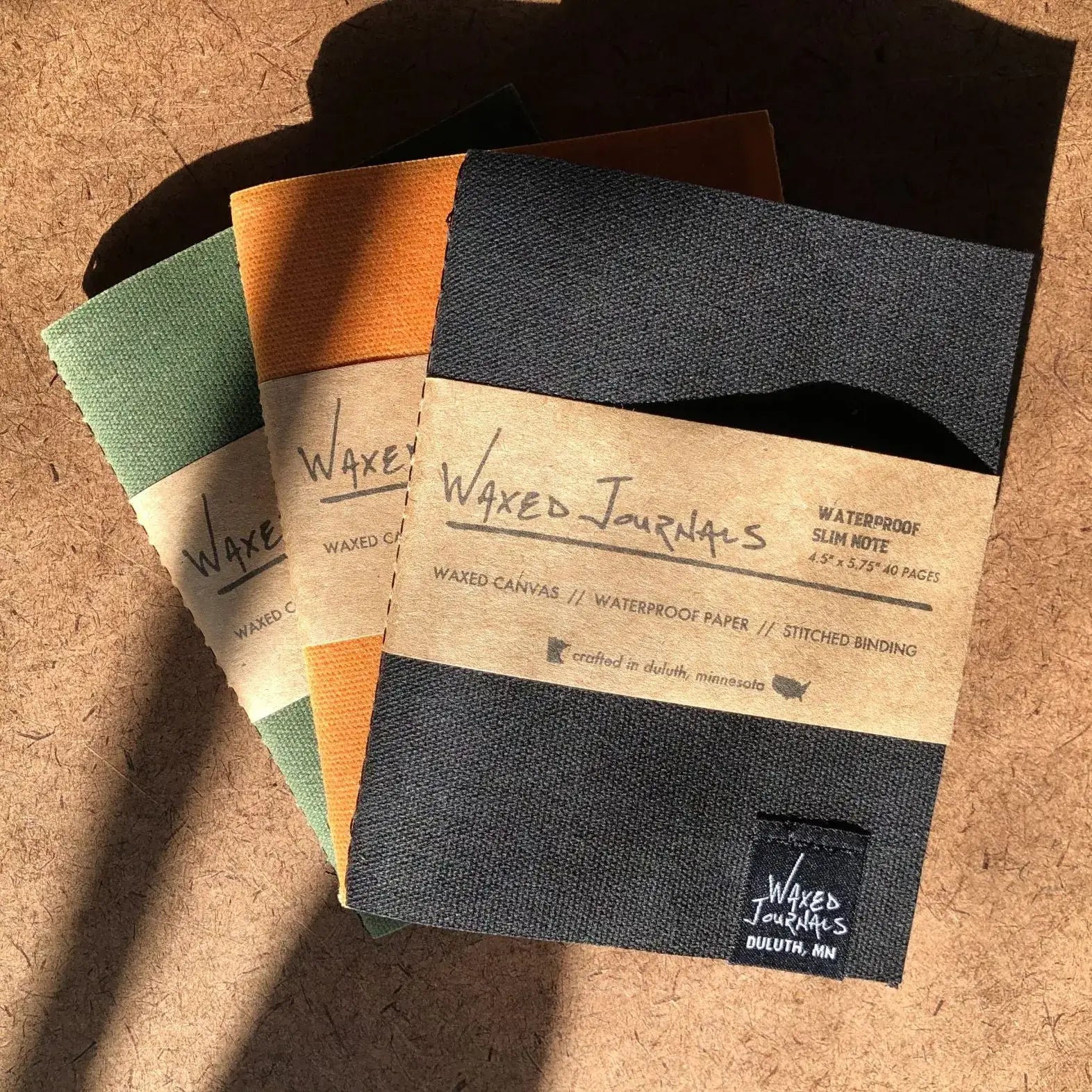 Multiple colors of waxed journal notebooks.